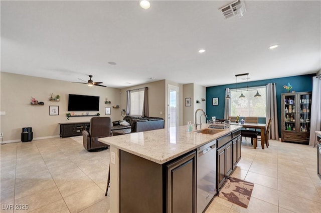 6334 Orions Belt Peak St, North Las Vegas, NV 89031 - kitchen with stainless steel dishwasher, a sink, light tile patterned flooring, a kitchen island with sink, and light stone counters