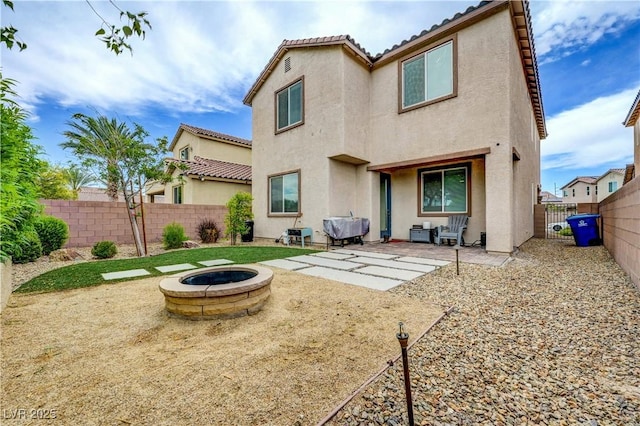 6334 Orions Belt Peak St, North Las Vegas, NV 89031 - back of house featuring a fire pit, stucco siding, a fenced backyard, a patio area, and a tile roof