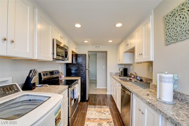 745 N Royal Crest Cir Unit 127, Las Vegas, NV 89169 - kitchen with washer / dryer, stainless steel appliances, a sink, white cabinets, and wood tiled floors