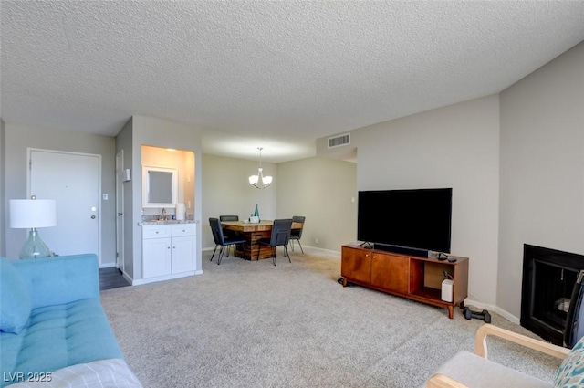 745 N Royal Crest Cir Unit 127, Las Vegas, NV 89169 - carpeted living room with a textured ceiling, a chandelier, and baseboards