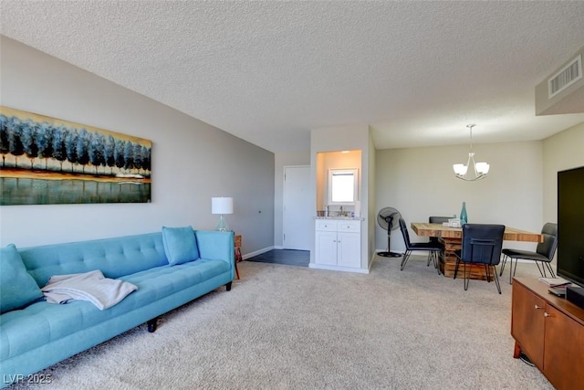 745 N Royal Crest Cir Unit 127, Las Vegas, NV 89169 - living area featuring a chandelier, light colored carpet, a textured ceiling, and baseboards
