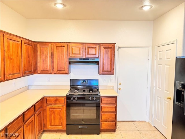 5653 Mount Athos St, North Las Vegas, NV 89031 - kitchen with black appliances, under cabinet range hood, light countertops, light tile patterned flooring, and brown cabinets