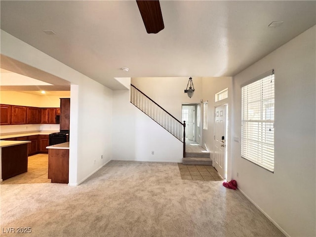 5653 Mount Athos St, North Las Vegas, NV 89031 - foyer featuring light colored carpet, stairs, ceiling fan, and baseboards