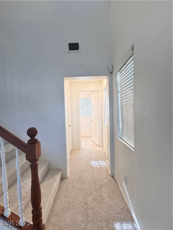 5653 Mount Athos St, North Las Vegas, NV 89031 - hallway with light carpet, stairs, and baseboards