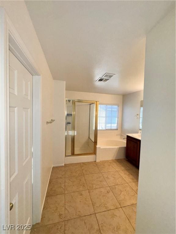5653 Mount Athos St, North Las Vegas, NV 89031 - full bath featuring vanity, a garden tub, a stall shower, and tile patterned floors
