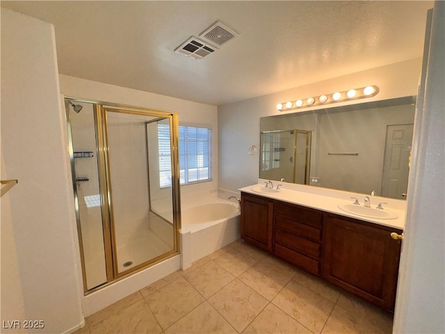 5653 Mount Athos St, North Las Vegas, NV 89031 - bathroom featuring a bath, a shower stall, double vanity, and tile patterned flooring