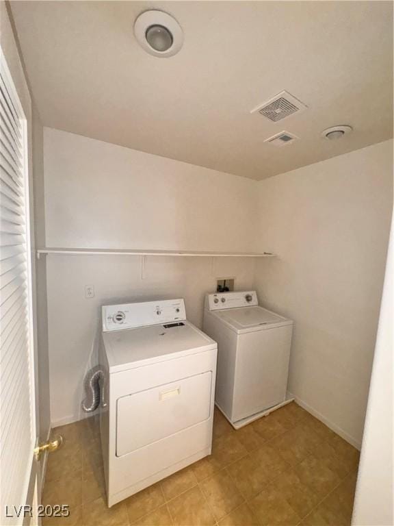 5653 Mount Athos St, North Las Vegas, NV 89031 - laundry area featuring washer and clothes dryer, light tile patterned flooring, and baseboards