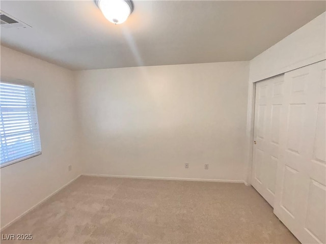 5653 Mount Athos St, North Las Vegas, NV 89031 - unfurnished bedroom with light colored carpet, baseboards, and a closet
