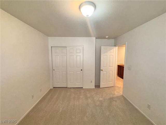 5653 Mount Athos St, North Las Vegas, NV 89031 - unfurnished bedroom with baseboards, light colored carpet, and a closet