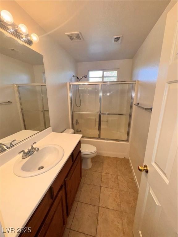 5653 Mount Athos St, North Las Vegas, NV 89031 - bathroom with vanity, toilet, shower / bath combination with glass door, and tile patterned flooring