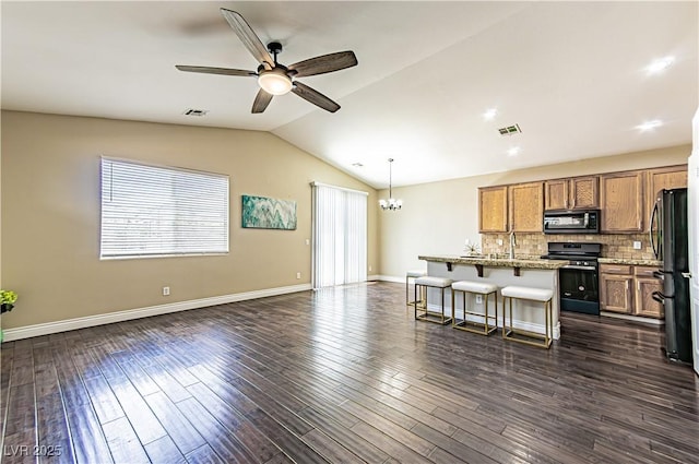 5079 Quiet Falls Ct, Las Vegas, NV 89141 - kitchen with appliances with stainless steel finishes, a breakfast bar, ceiling fan, open floor plan, and brown cabinetry
