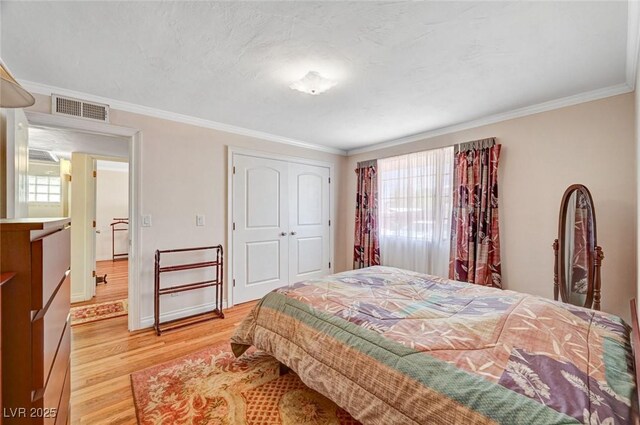 557 6th St, Boulder City, NV 89005 - bedroom with light wood-style flooring, crown molding, and a closet