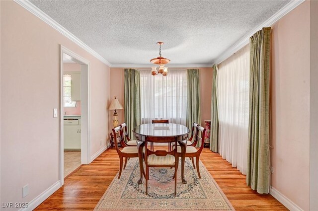 557 6th St, Boulder City, NV 89005 - dining space featuring light wood-style floors, a textured ceiling, crown molding, baseboards, and a chandelier