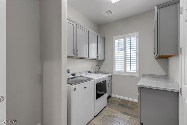 7072 Arabian Ridge St, Las Vegas, NV 89131 - laundry area featuring cabinet space, washing machine and clothes dryer, baseboards, and light wood finished floors