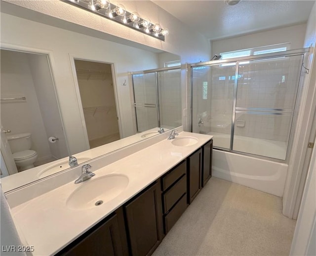8682 Gateway Glen Dr, Las Vegas, NV 89178 - full bathroom featuring toilet, double vanity, bath / shower combo with glass door, and a walk in closet