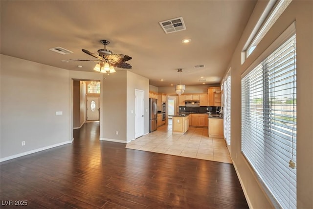 1740 Flores Ln, Henderson, NV 89012 - kitchen with open floor plan, light brown cabinets, light wood-type flooring, stainless steel appliances, and recessed lighting