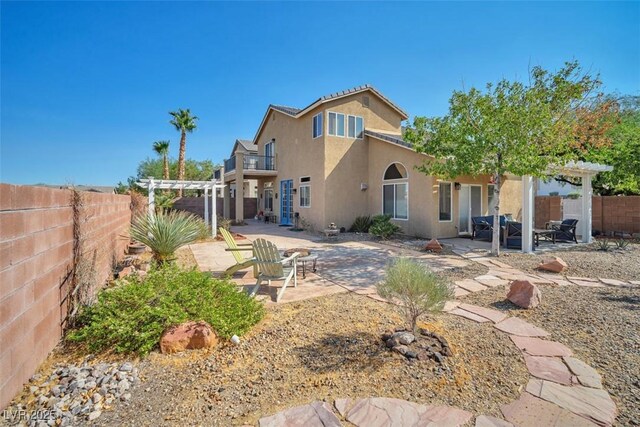 1740 Flores Ln, Henderson, NV 89012 - rear view of house featuring a pergola, a balcony, a patio, stucco siding, and a fenced backyard
