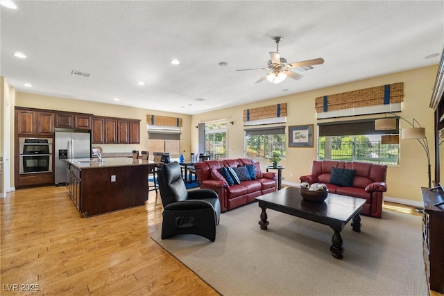 5747 Jaborandi Ave, Pahrump, NV 89061 - living room featuring light wood-type flooring, ceiling fan, recessed lighting, baseboards, and a textured ceiling