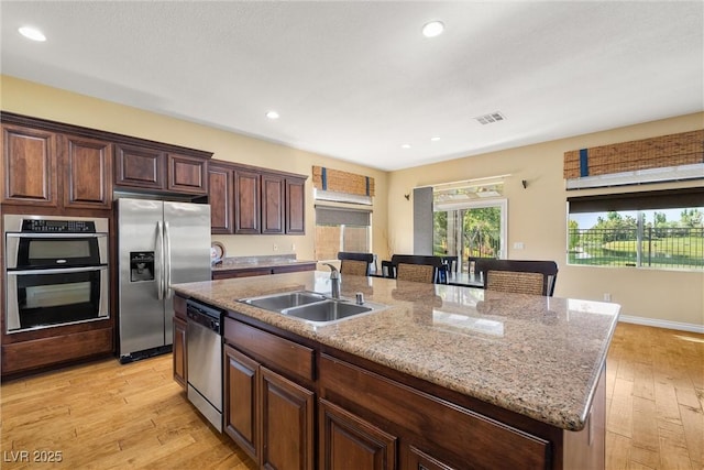 5747 Jaborandi Ave, Pahrump, NV 89061 - kitchen with stainless steel appliances, a sink, a center island with sink, light wood-style flooring, and recessed lighting