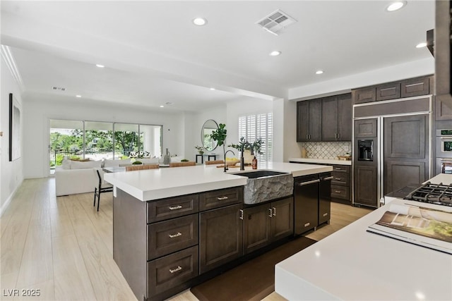 11775 Woodbrook Ct, Las Vegas, NV 89141 - kitchen with a sink, recessed lighting, light countertops, a center island with sink, and light wood finished floors
