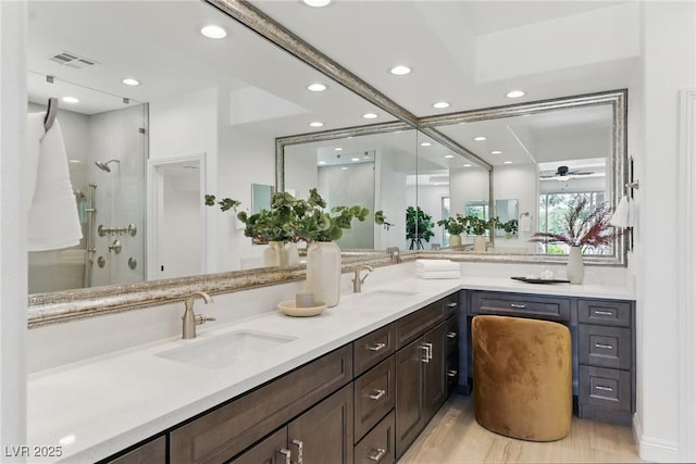 11775 Woodbrook Ct, Las Vegas, NV 89141 - bathroom featuring double vanity, recessed lighting, a stall shower, a ceiling fan, and wood finished floors
