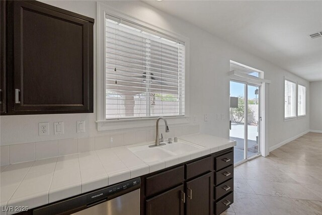 829 Dancing Vines Ave, Las Vegas, NV 89183 - kitchen featuring a sink, dark brown cabinetry, stainless steel dishwasher, tile countertops, and light tile patterned floors