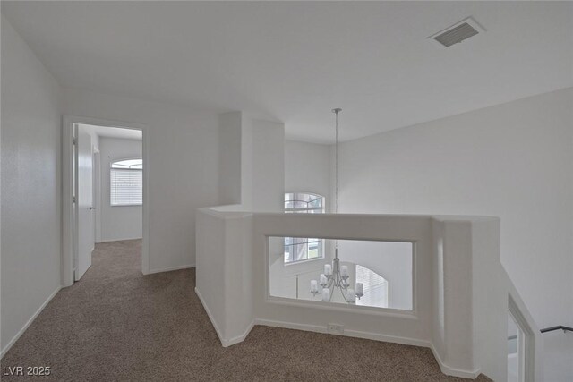 829 Dancing Vines Ave, Las Vegas, NV 89183 - hall featuring carpet flooring, an upstairs landing, a chandelier, and baseboards