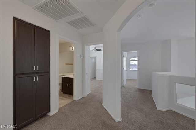 829 Dancing Vines Ave, Las Vegas, NV 89183 - hallway featuring arched walkways, light colored carpet, and baseboards