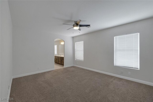 829 Dancing Vines Ave, Las Vegas, NV 89183 - spare room featuring a ceiling fan, arched walkways, light carpet, and baseboards