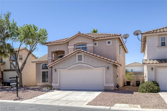 829 Dancing Vines Ave, Las Vegas, NV 89183 - mediterranean / spanish-style home with driveway, stucco siding, central air condition unit, a tiled roof, and an attached garage