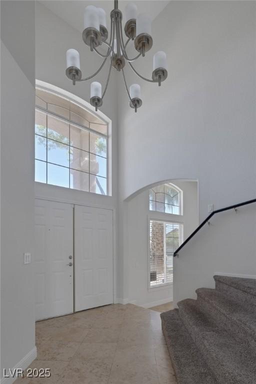 829 Dancing Vines Ave, Las Vegas, NV 89183 - tiled entrance foyer featuring a chandelier, a high ceiling, stairs, and baseboards