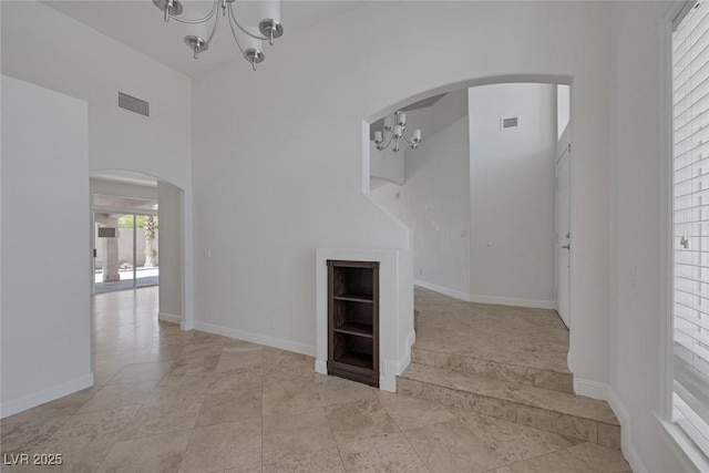 829 Dancing Vines Ave, Las Vegas, NV 89183 - unfurnished room featuring a chandelier, arched walkways, a high ceiling, and baseboards