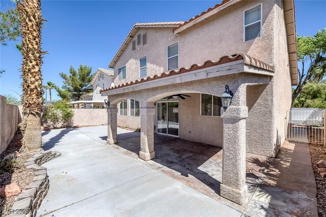 829 Dancing Vines Ave, Las Vegas, NV 89183 - back of house featuring stucco siding, a fenced backyard, a tiled roof, and a patio