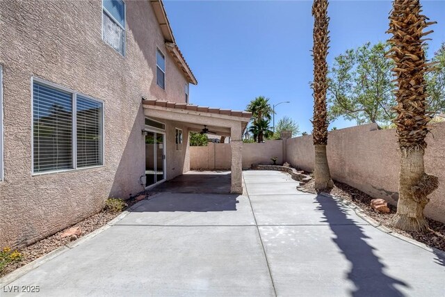 829 Dancing Vines Ave, Las Vegas, NV 89183 - fenced backyard with ceiling fan and a patio area