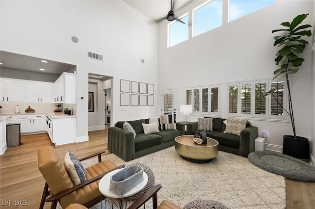 11340 Espadrille Ct, Las Vegas, NV 89138 - living room featuring light wood-type flooring, a towering ceiling, baseboards, and a ceiling fan