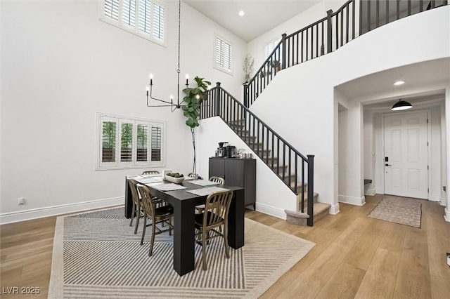 11340 Espadrille Ct, Las Vegas, NV 89138 - dining space with a high ceiling, stairs, baseboards, light wood-type flooring, and a chandelier