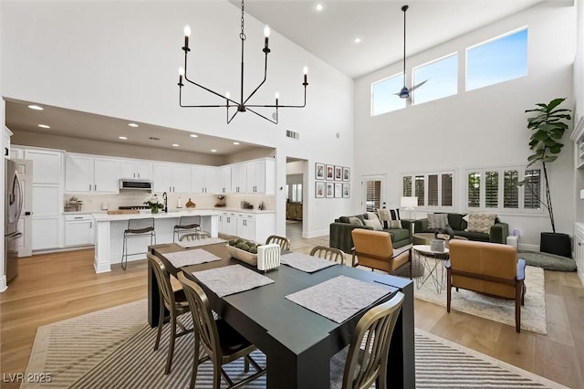 11340 Espadrille Ct, Las Vegas, NV 89138 - dining space featuring a towering ceiling, light wood-type flooring, a chandelier, recessed lighting, and baseboards