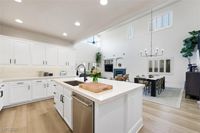 11340 Espadrille Ct, Las Vegas, NV 89138 - kitchen with a sink, dishwasher, light wood finished floors, white cabinetry, and a high ceiling