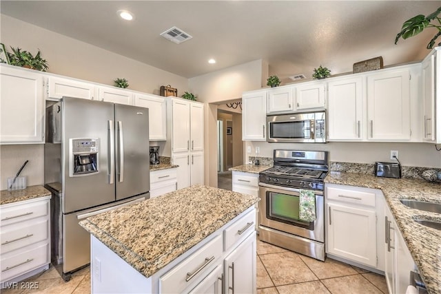 344 Golden Shore Dr, Las Vegas, NV 89123 - kitchen featuring appliances with stainless steel finishes, white cabinetry, light stone countertops, a kitchen island, and recessed lighting