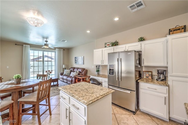344 Golden Shore Dr, Las Vegas, NV 89123 - kitchen featuring stainless steel refrigerator with ice dispenser, a kitchen island, white cabinets, light tile patterned floors, and ceiling fan