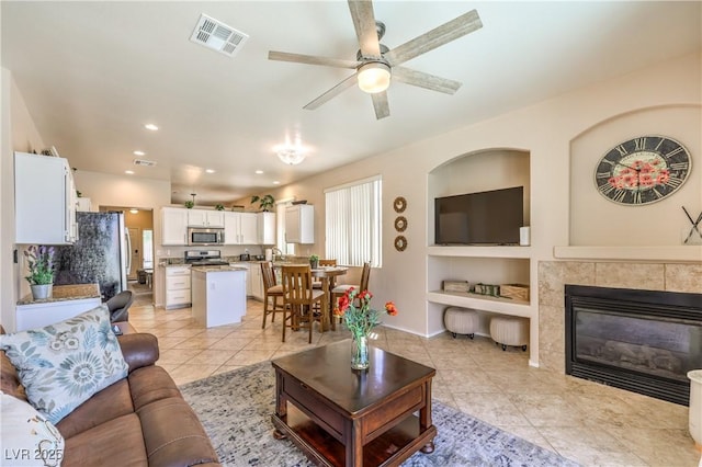 344 Golden Shore Dr, Las Vegas, NV 89123 - living area with light tile patterned floors, ceiling fan, a tile fireplace, recessed lighting, and built in shelves