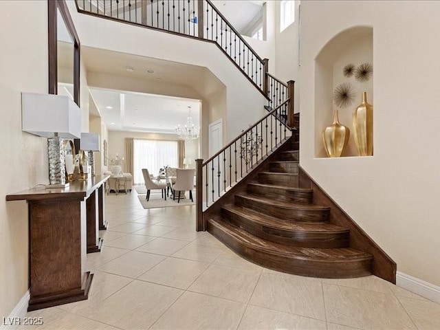 2400 Trissino Ct, Henderson, NV 89044 - stairs with a towering ceiling, baseboards, a chandelier, tile patterned floors, and arched walkways