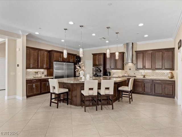 2400 Trissino Ct, Henderson, NV 89044 - kitchen with stainless steel built in refrigerator, wall chimney range hood, tasteful backsplash, a breakfast bar, and recessed lighting