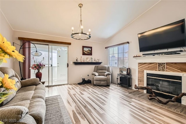2725 S Nellis Blvd Unit 2084, Las Vegas, NV 89121 - living room featuring vaulted ceiling, wood finished floors, a chandelier, and a tiled fireplace