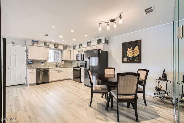 2725 S Nellis Blvd Unit 2084, Las Vegas, NV 89121 - kitchen with stainless steel appliances, a sink, light wood-style floors, white cabinets, and recessed lighting