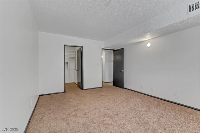 1390 Vegas Valley Dr Unit 26, Las Vegas, NV 89169 - unfurnished bedroom with carpet floors, a textured ceiling, a spacious closet, and baseboards