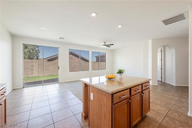 909 Trinity Pond Cir, Henderson, NV 89002 - kitchen featuring arched walkways, ceiling fan, light tile patterned floors, a center island, and recessed lighting