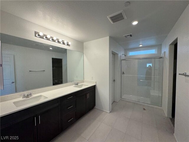 5175 Capucina St Lot 5, Las Vegas, NV 89122 - full bathroom with a shower stall, double vanity, baseboards, a textured ceiling, and tile patterned floors