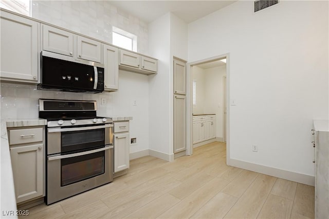 10309 Georgetown Pl, Las Vegas, NV 89134 - kitchen with stainless steel appliances, light wood-type flooring, light countertops, decorative backsplash, and baseboards