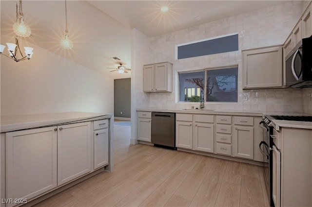 10309 Georgetown Pl, Las Vegas, NV 89134 - kitchen featuring stainless steel appliances, a sink, light wood-style floors, tasteful backsplash, and light countertops